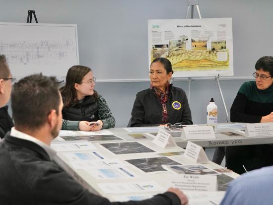 Secretary Haaland and others sit around a table in discussion
