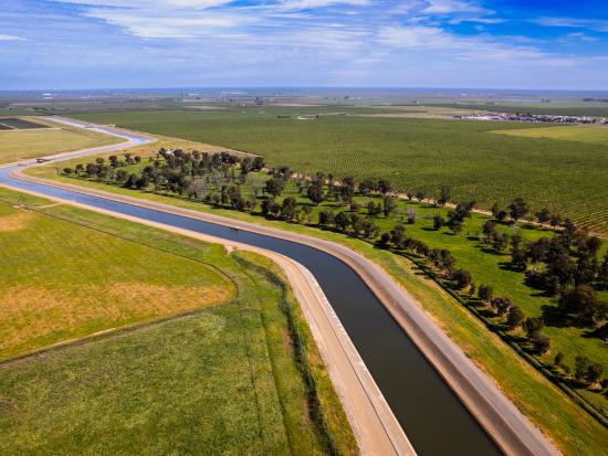 Canal running through green valley. 
