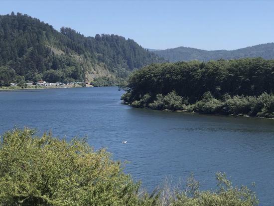 River surrounded by green mountain landscape. 