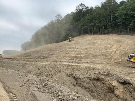 Construction along sloped dirt hill. 