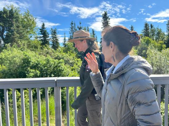 Secretary Haaland and park ranger walk along wooded boardwalk