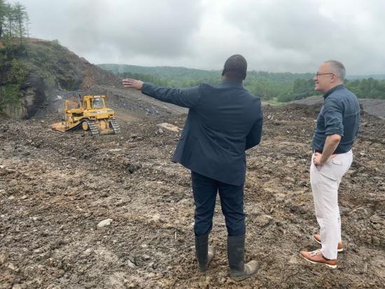 Two men standing in rocky/dirt area
