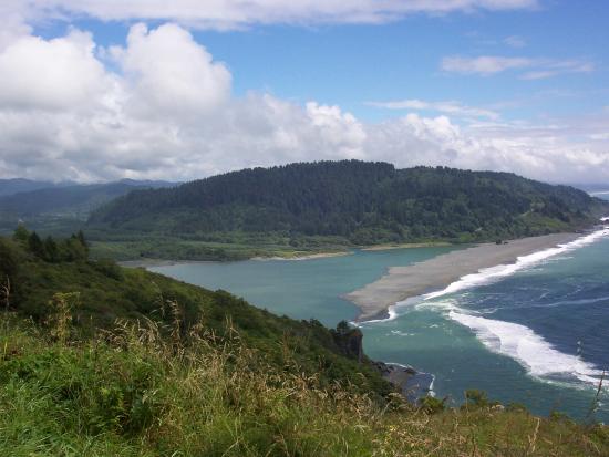 River and ocean meeting under blue cloudy skies.