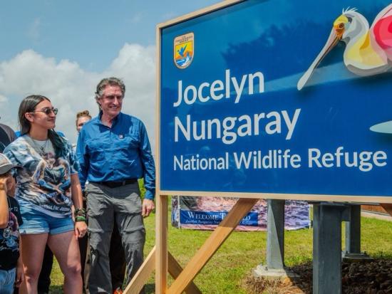 Secretary Doug Burgum standing next to new Jocelyn Nungaray sign. 