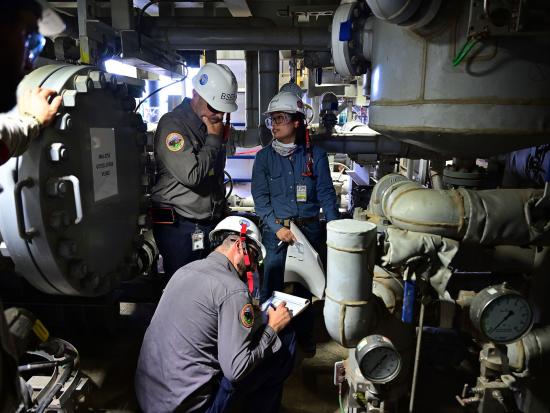 BSEE inspectors looking at equipment and paperwork. 