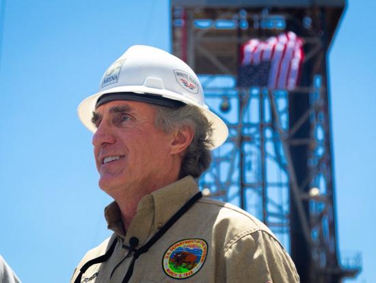 Secretary Burgum in hard hat with American flag in background