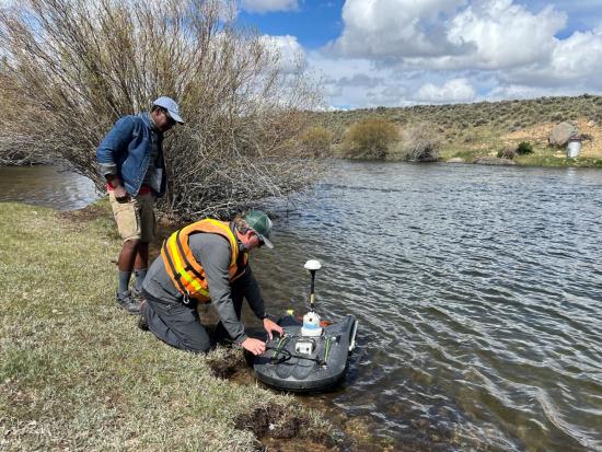 A streamgage is deployed by two people in Wyoming
