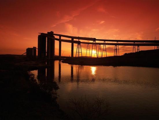 Coal mining operation at sunrise with red orange colored sky