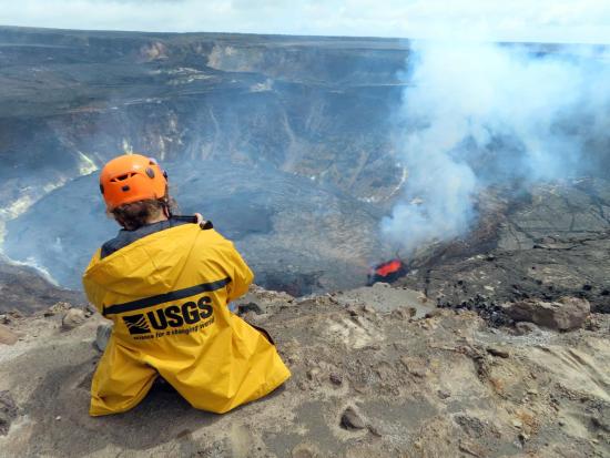 USGS Employee in yellow jacket monitoring volcano.
