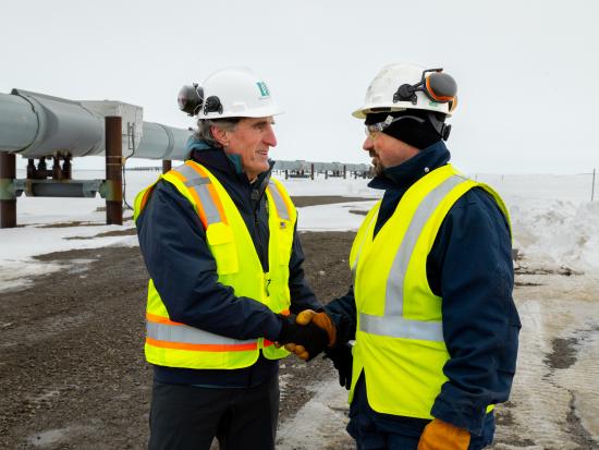 Secretary Burgum shaking hands with man in safety vest at Alaska pipeline