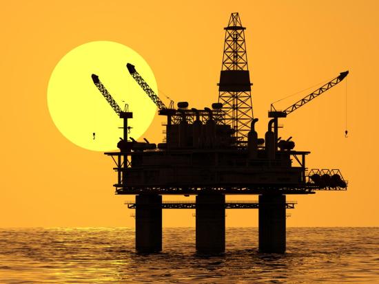 Offshore platform in yellow orange sunset.