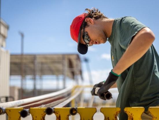 Person in hard hat welding.