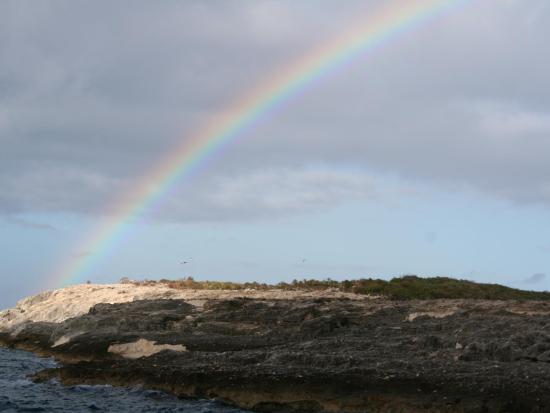 Image of island coastline with clouds and rainbow