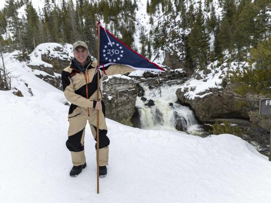 Secretary Burgum Holding GAE Flag in snowy landscape