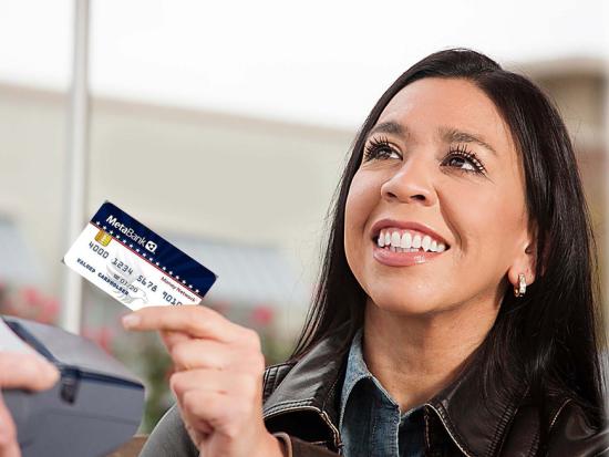 A person smiles while receiving a debit card