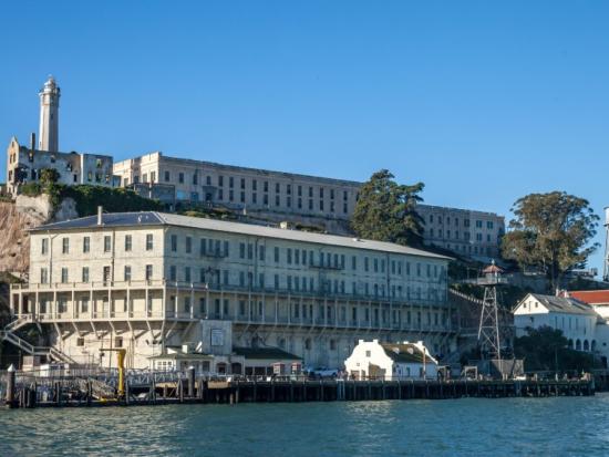 A view of the dock at Alcatraz Island with the cell house and lighthouse in the background