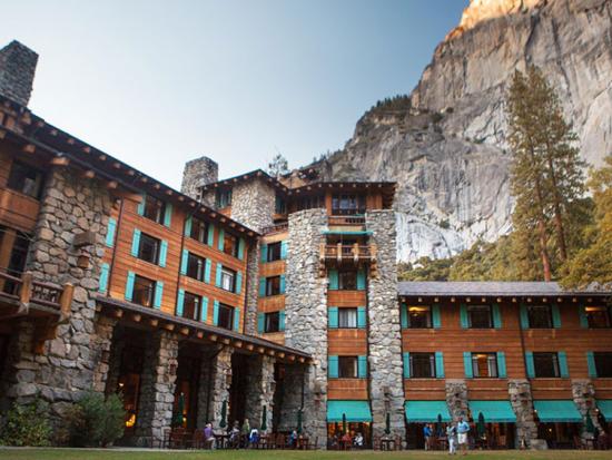 The Ahwahnee with visitors in foreground on lawn and at tables