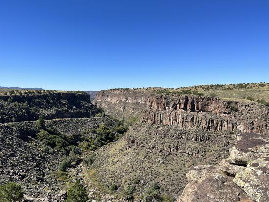 View of a gorge in the Rio Grande del Norte National Monument covered in rocks and shrubs