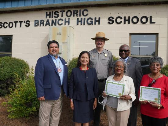 Secretary Haaland and other officials standing in front of Historic Scott's Branch High School