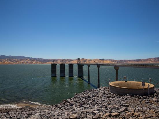 Dam and reservoir in desert landscape.