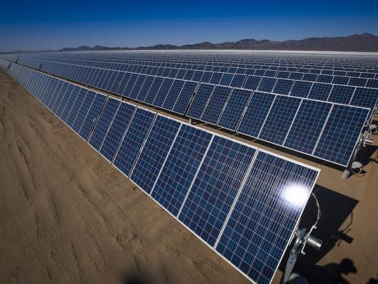 Rows of solar panels in a desert landscape. 