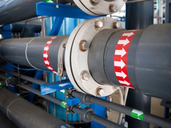 Water recycling equipment including 3 pipes with green, red, and blue arrows marking the direction of water flow. 