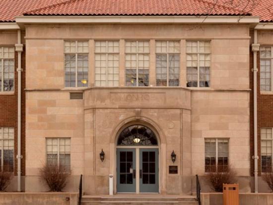 Exterior of a brick building the word "Monroe" engraved.