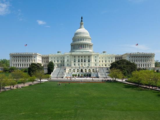 The U.S. Capitol Building in sunshine with green grass in front
