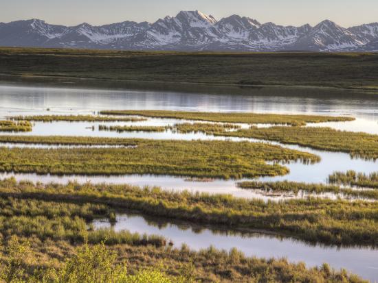 A lake in front of a snow-capped mountain range