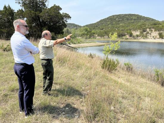 Tommy Beaudreau stands alongside another person near a lake