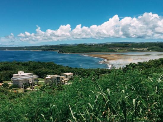A small village sits on the shoreline of Guam with a view of the ocean