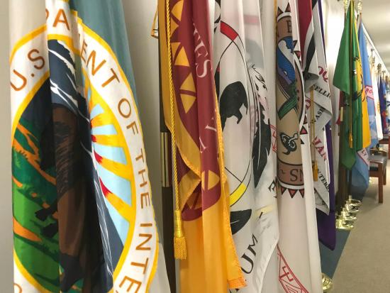 Colorful tribal flags line a long hallway.