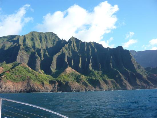 The Napali Coast of Kauai, Hawaii, with blue ocean water and green cliffs behind