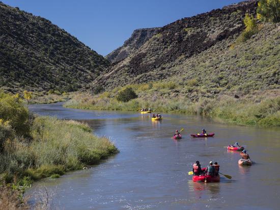 Kayakers paddle down the Rio Grande at Rio Grande del Norte National Monument