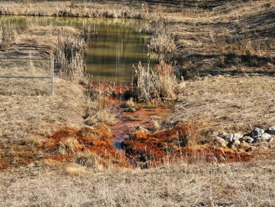 A green river with orange pollution