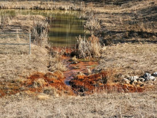 A green river with orange pollution