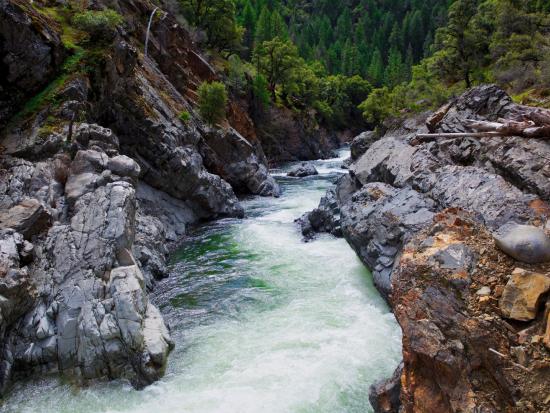 River cuts through rocky, forested terrain.