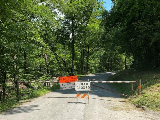 Gravel road with closed gate and sign