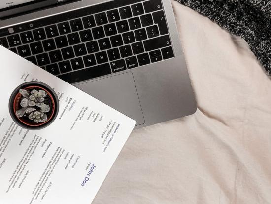 Picture of a Resume on top of a laptop computer