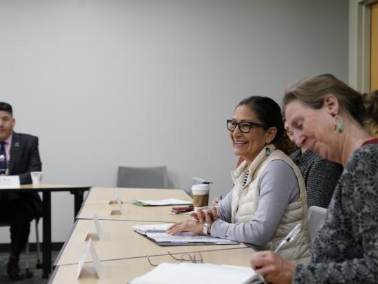 Secretary Haaland sits at a table with infrastructure leaders.