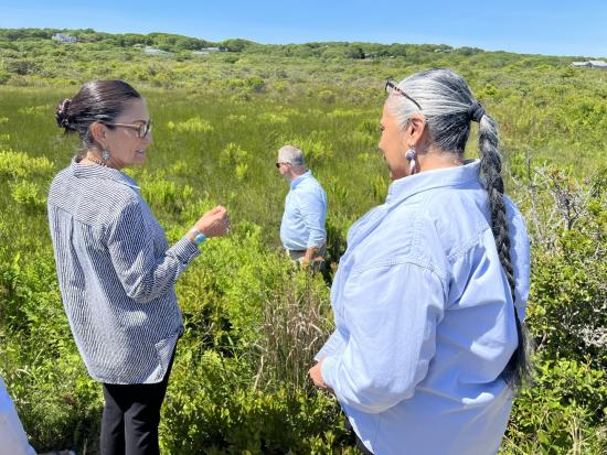 Secretary Haaland and two others in green grassy field