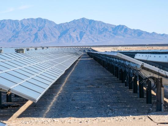 Solar panels in front of mountains.