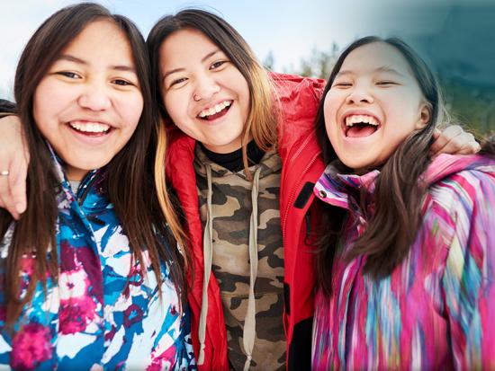 Three young people laughing while their picture is taken