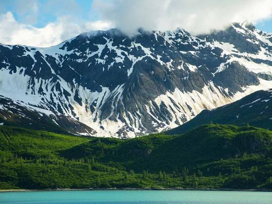 Snow-capped mountains under a cloudy sky at Glacier Bay National Park and Preserve.