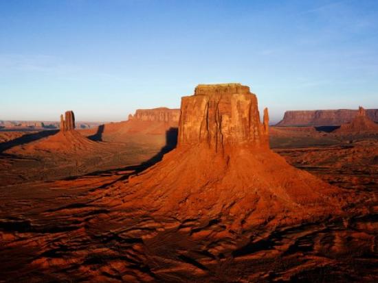 Large red stone monoliths rise from a desert landscape