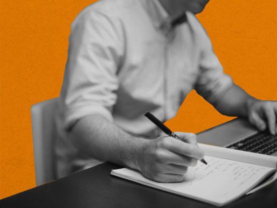 Image of a person writing in a notebook