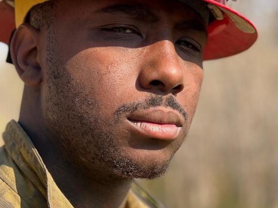 A close up photo of a wildland firefighter's face and helmet. 