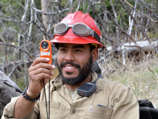 A wildland firefighter holds a weather assessment tool during spring training. 