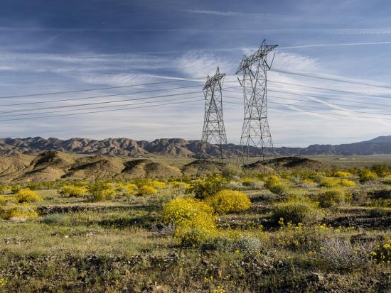 Transmission lines under a cloudy sky in Californian desert.