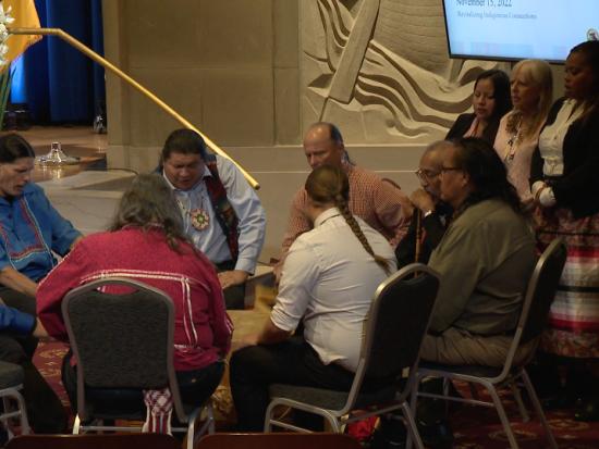 Indigenous men take part in a drum circle in the Yates Auditorium at the Stewart Lee Udall Building